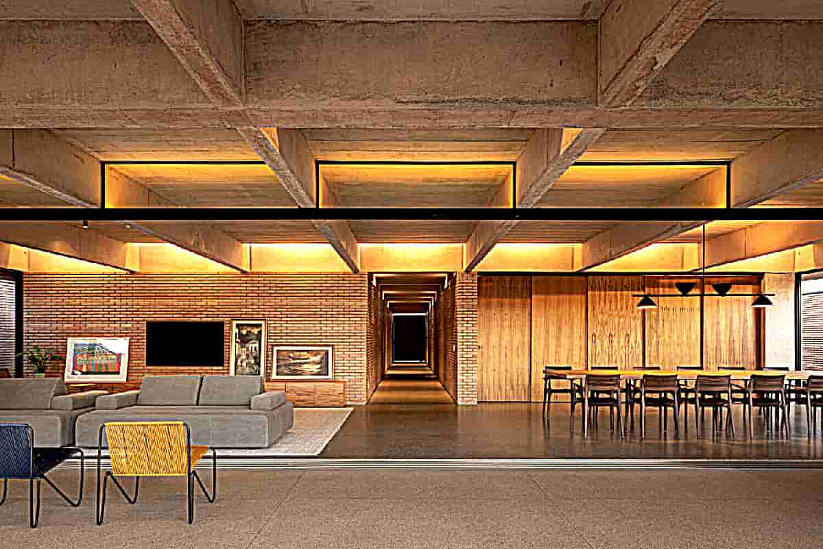 2-1txt) [The roof structure of the house is formed by 8 exposed concrete beams cast in place. With a length of 30.5 meters and spaced 2.10 meters apart. The beams are interspersed with exposed beams of the slab-panel type. A second mesh of perpendicular beams follows the internal divisions of the rooms and “ties together” the whole structure]. At some specific points (access gallery, bathrooms, circulations and internal sections of the room and balcony); The placement of the slab-panel joists is interrupted by linear skylights for natural lighting and/or ventilation. Most of the luminaires are built into these skylights.