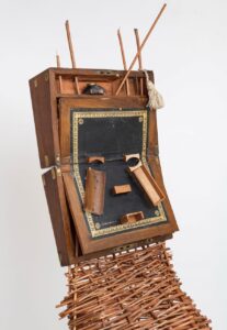 Sonia E. Barrett 的雕塑將古董書桌與非洲面具的翻轉融合