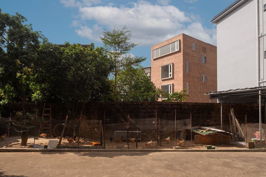brick house integrated with daily village life and surroundings