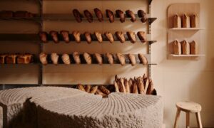 bakery interior with wooden shelves and rows of artisan bread in warm natural light