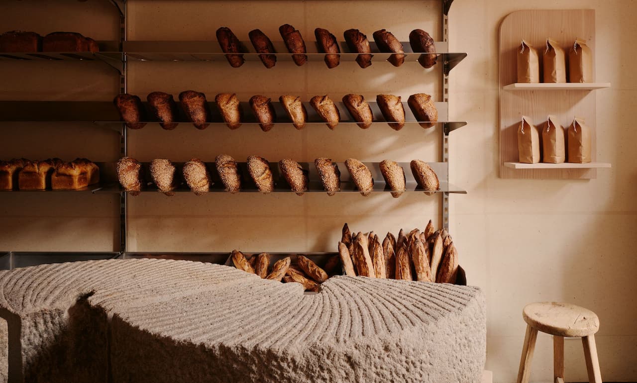 bakery interior with wooden shelves and rows of artisan bread in warm natural light