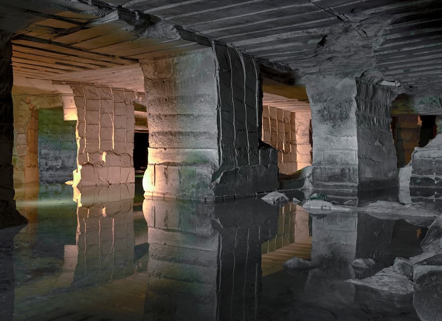 underground extraction chamber filled with water representing resource exploitation in subsurface architecture