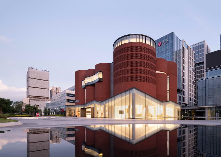 紅磚量體與玻璃基座交錯的建築外觀 廣州雪蕾香氛博物館