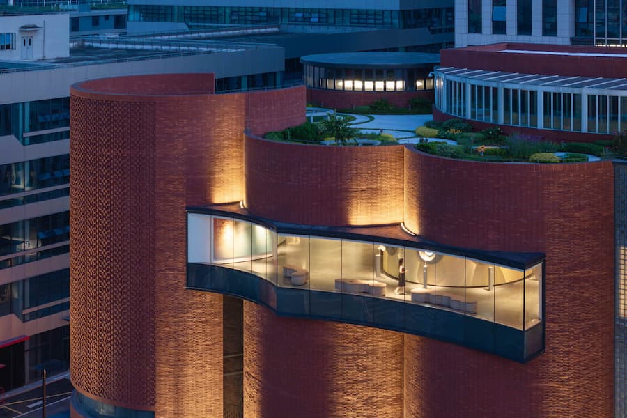 夜間懸挑玻璃廊道連接紅磚量體 廣州雪蕾香氛博物館