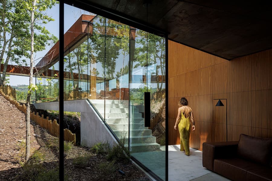 glass corridor running parallel to slope linking circulation and landscape