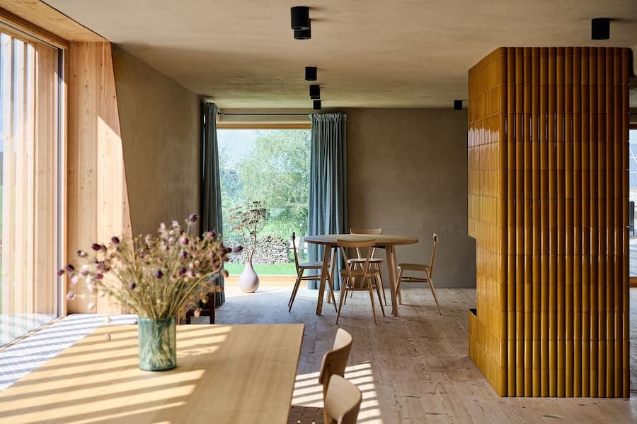 interior space defined by natural light wood surfaces and ceramic tiled column