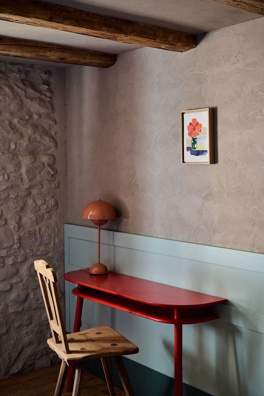 corner workspace with small desk integrated into textured wall and timber ceiling