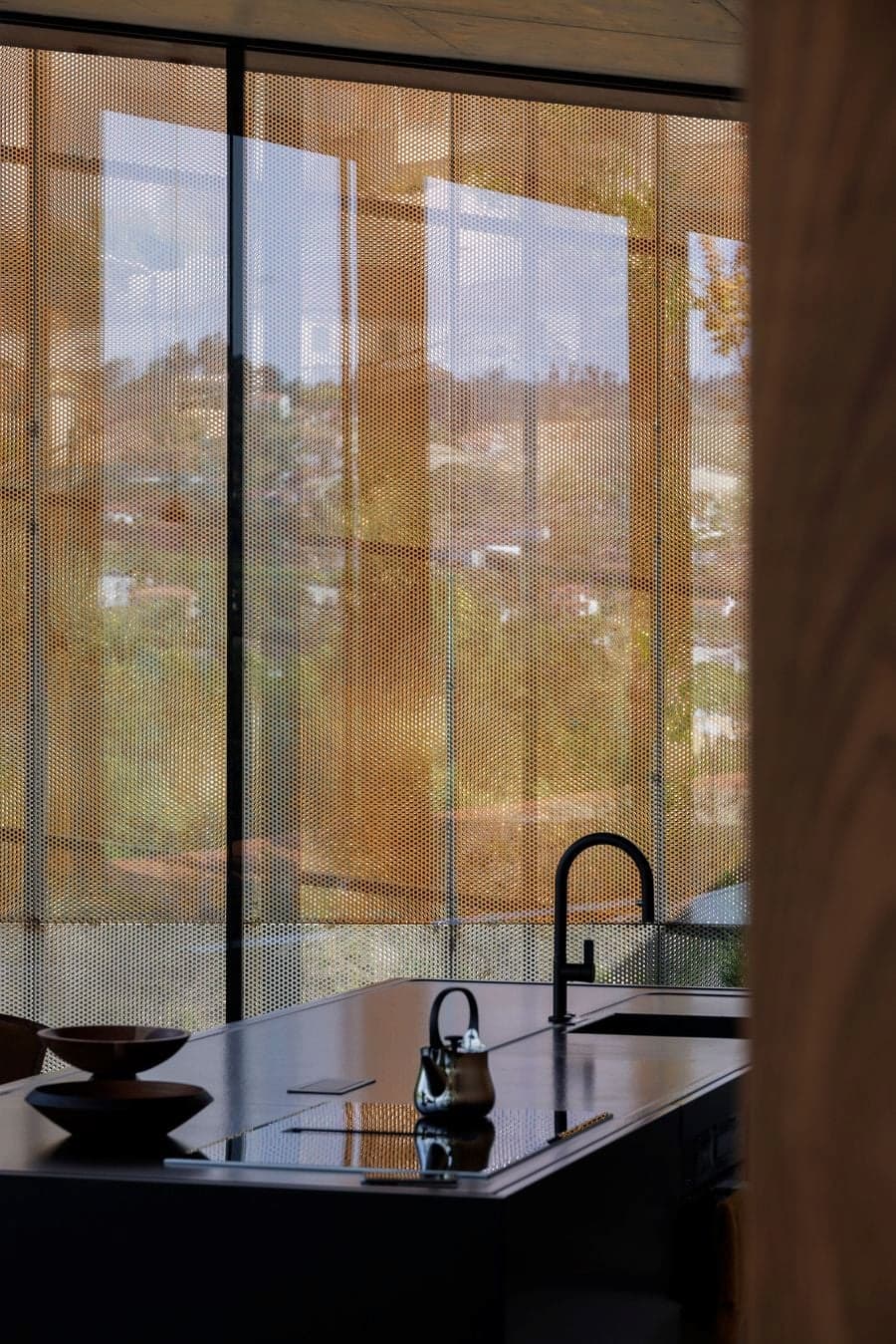 perforated corten steel screen filtering daylight and softening external visibility