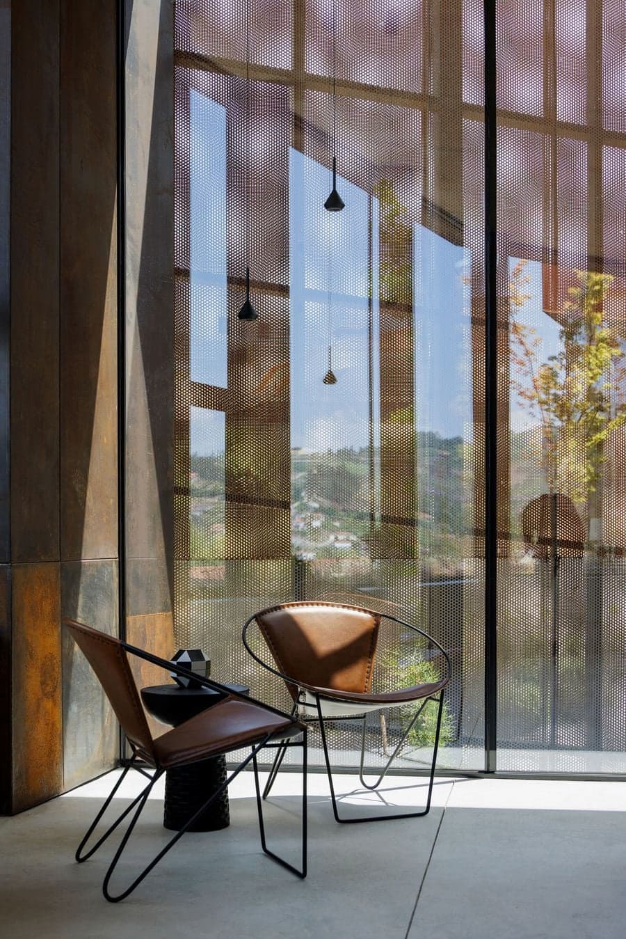 perforated corten steel screen filtering daylight and softening external visibility