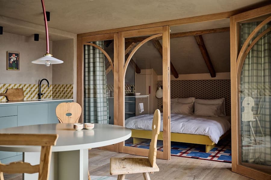 bedroom behind glass partition connected to dining space