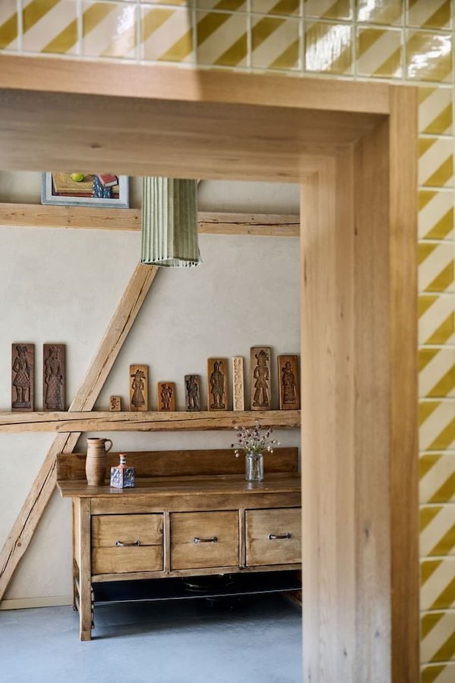 view framed through kitchen opening towards timber structure and furniture