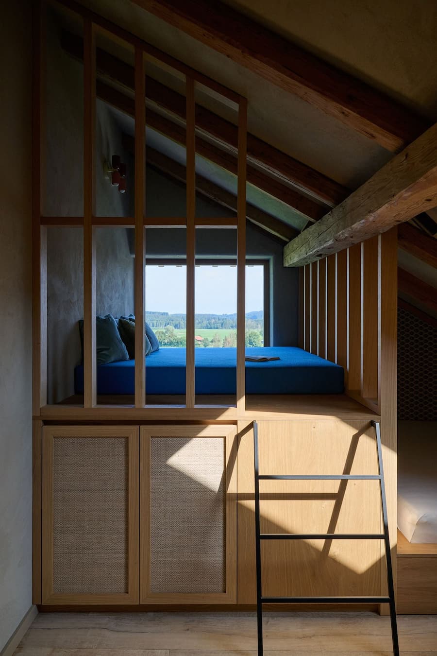 bed platform facing window view framed by wooden structure