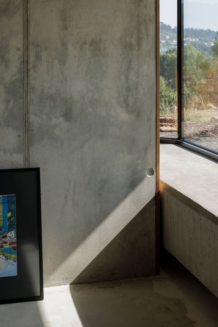 concrete wall intersecting with corner glass window forming a light interface and shadow plane