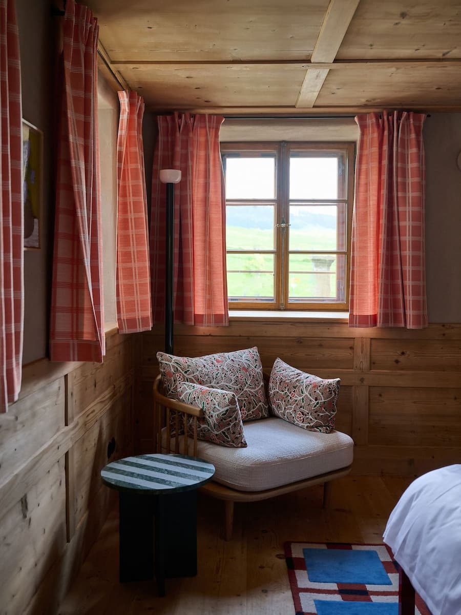 wood lined interior corner with patterned textiles and soft daylight filtering through window curtains