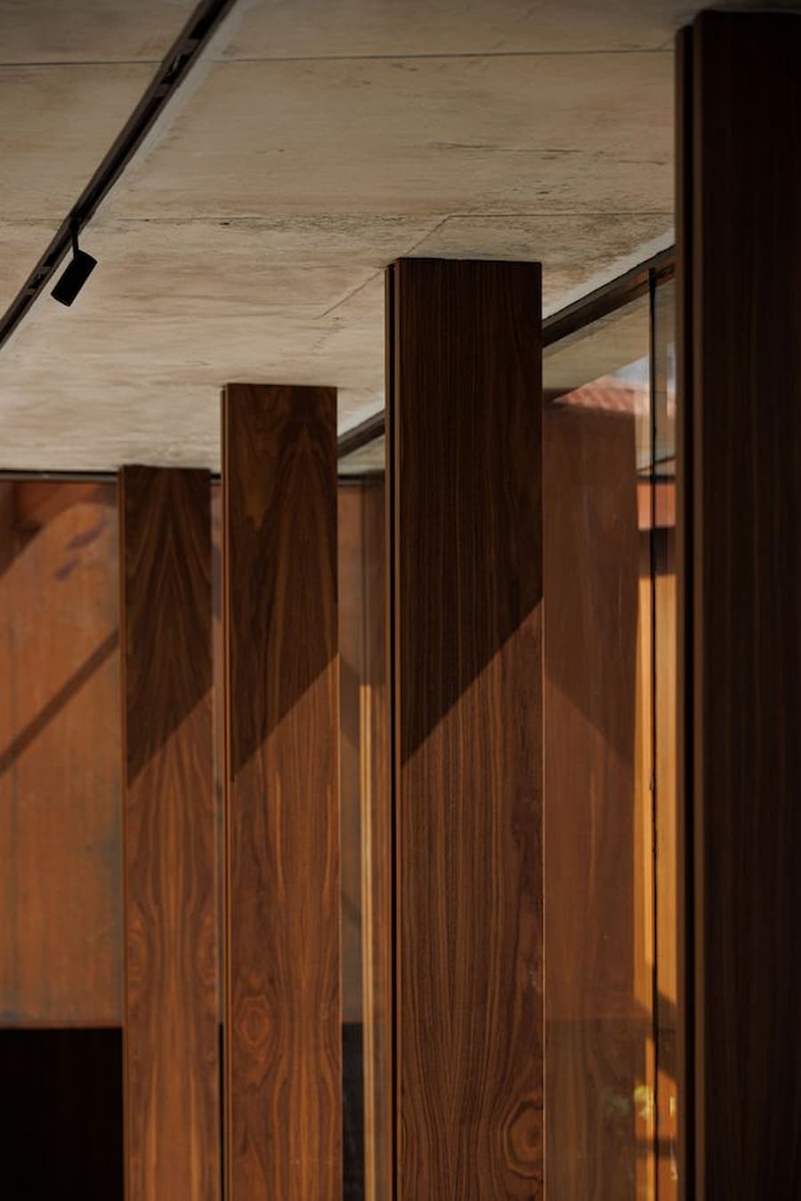 wood columns aligned with glass facade creating layered depth and structural rhythm
