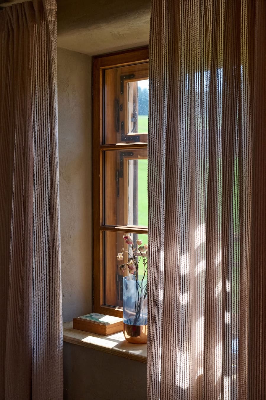 natural light passing through semi transparent curtains highlighting material texture and interior atmosphere