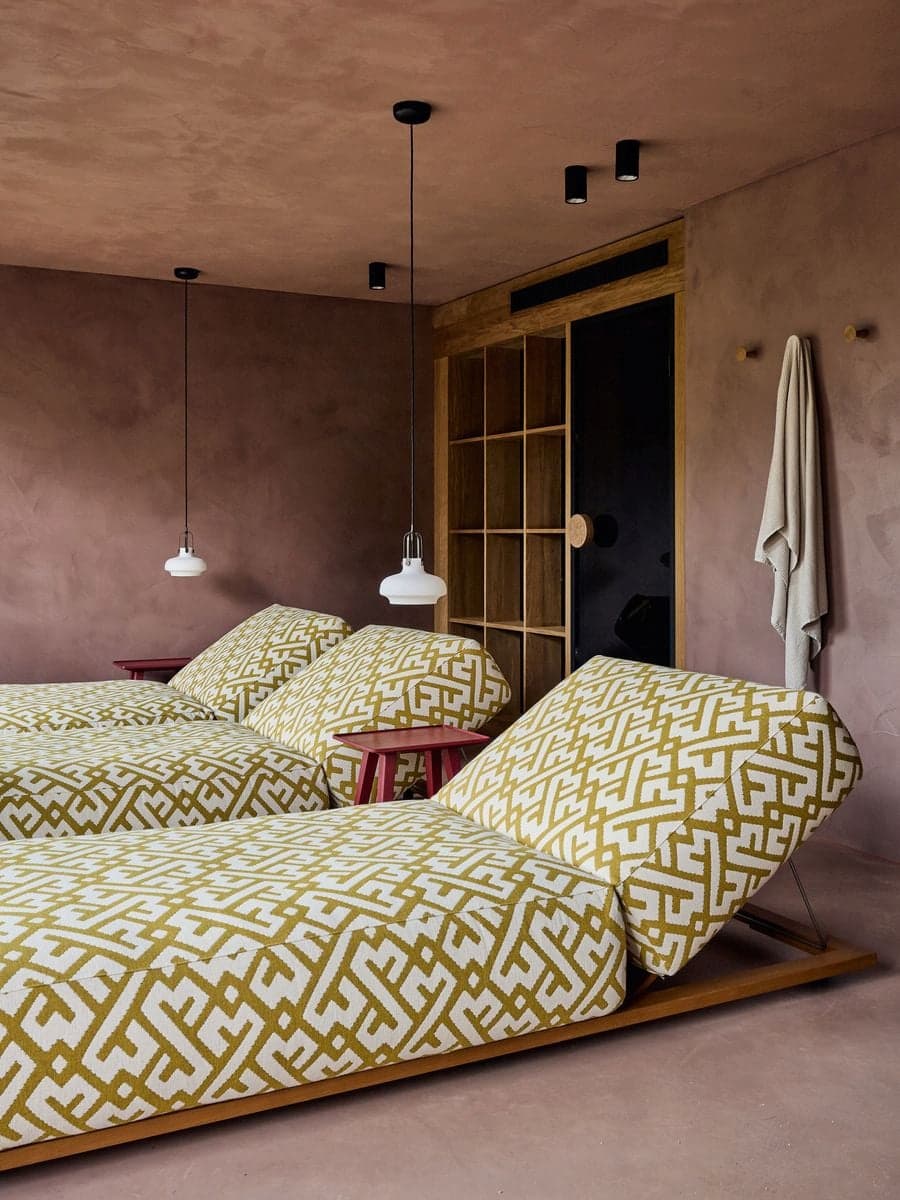 interior scene where red linear lighting elements create contrast against rustic materials