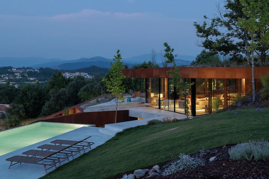 terrace and pool embedded into sloped terrain forming continuous landscape system