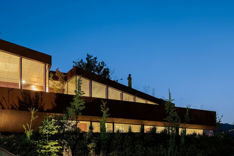 bedroom space framing exterior landscape through horizontal window opening embedded in concrete wall