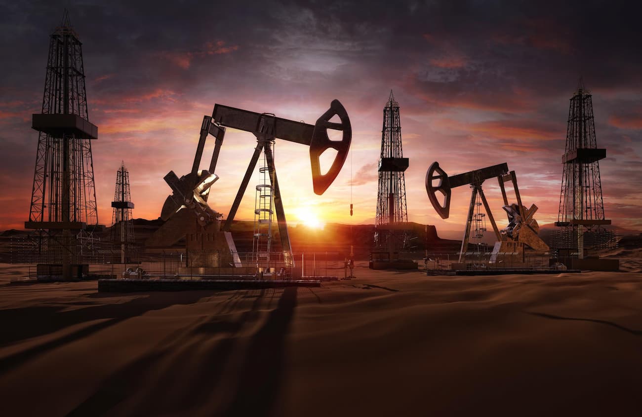 multiple oil pumpjacks operating in a desert field at sunset, representing large-scale petroleum extraction infrastructure