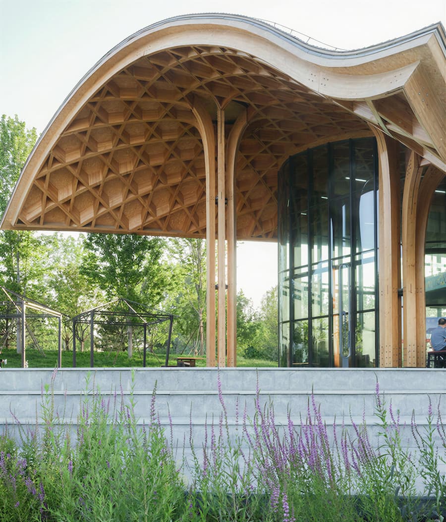 exterior view of lakefront restaurant with curved timber roof structure