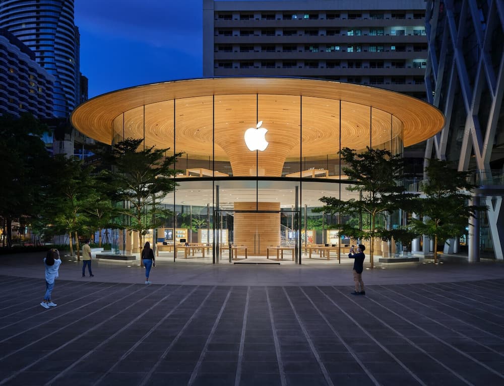 Apple Store at night with circular timber roof and glass facade