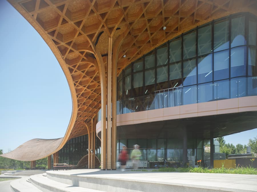 building reflected in lake with surrounding landscape and timber roof