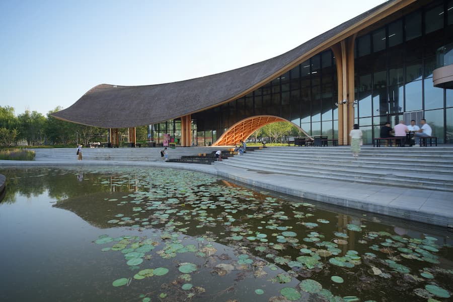 lakefront restaurant at sunset with curved timber roof and warm lighting