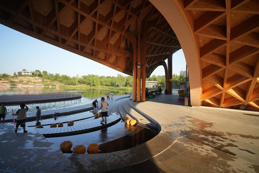 cantilevered glass volume under timber roof along building facade