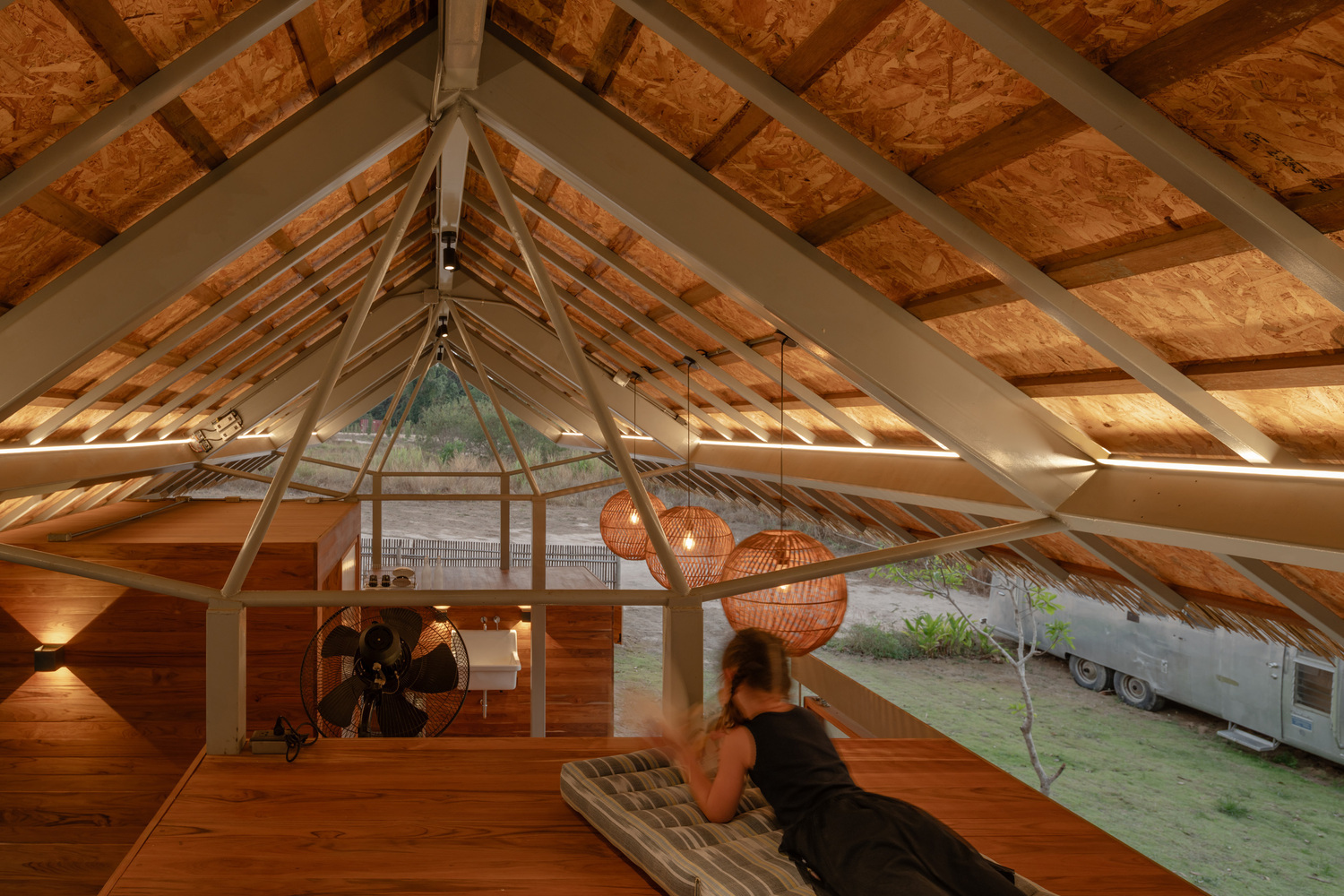 warm interior view of lightweight roof structure with exposed framing and open living space