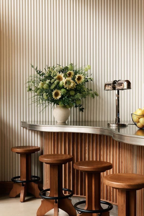 Minimalist hospitality bar area with floral arrangement and ribbed wall texture