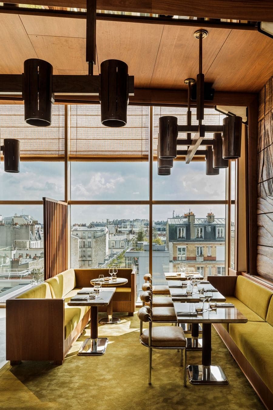 Rooftop restaurant interior overlooking the Paris skyline through floor-to-ceiling windows