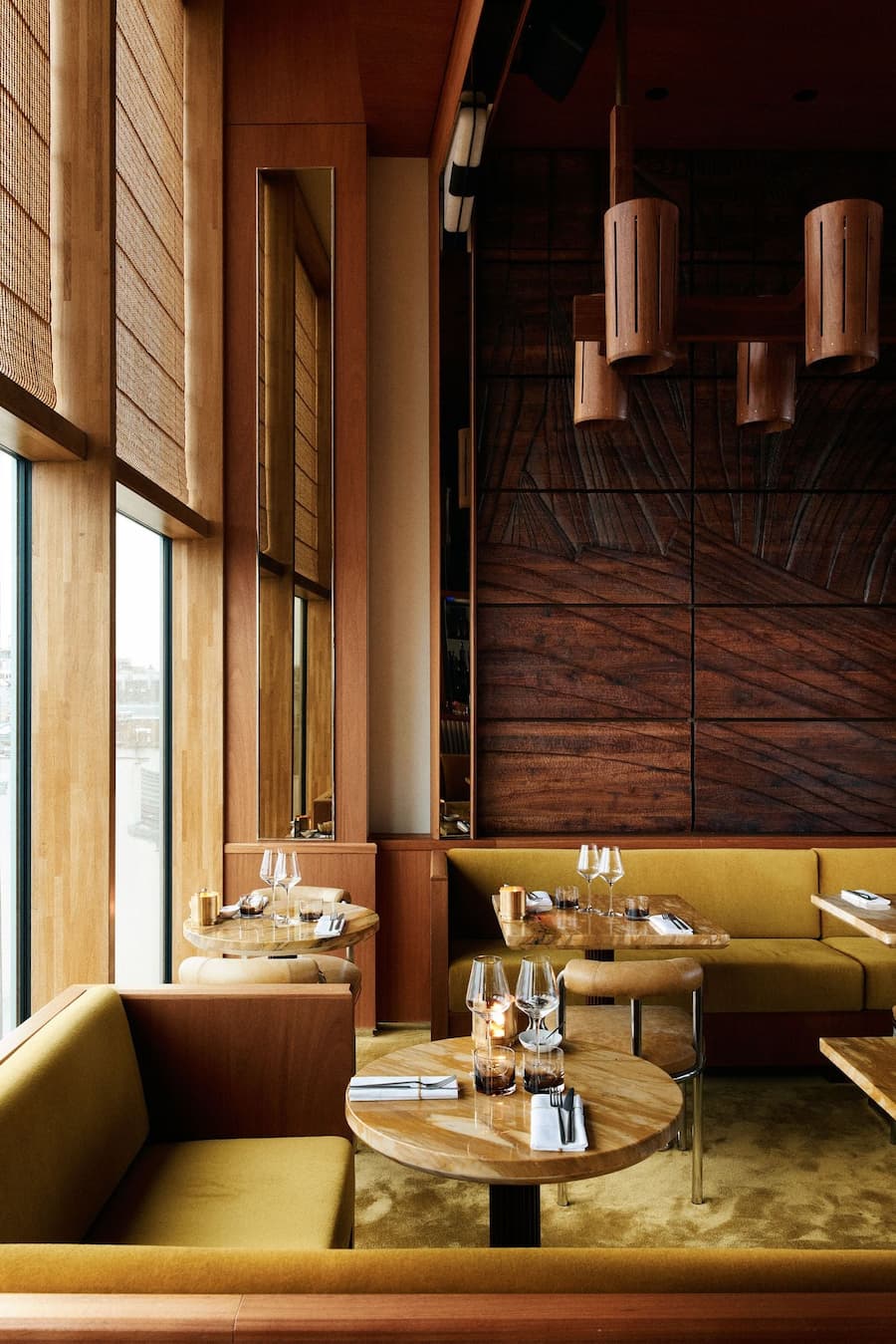 Intimate restaurant lounge with rich wood paneling, marble tables and ambient lighting