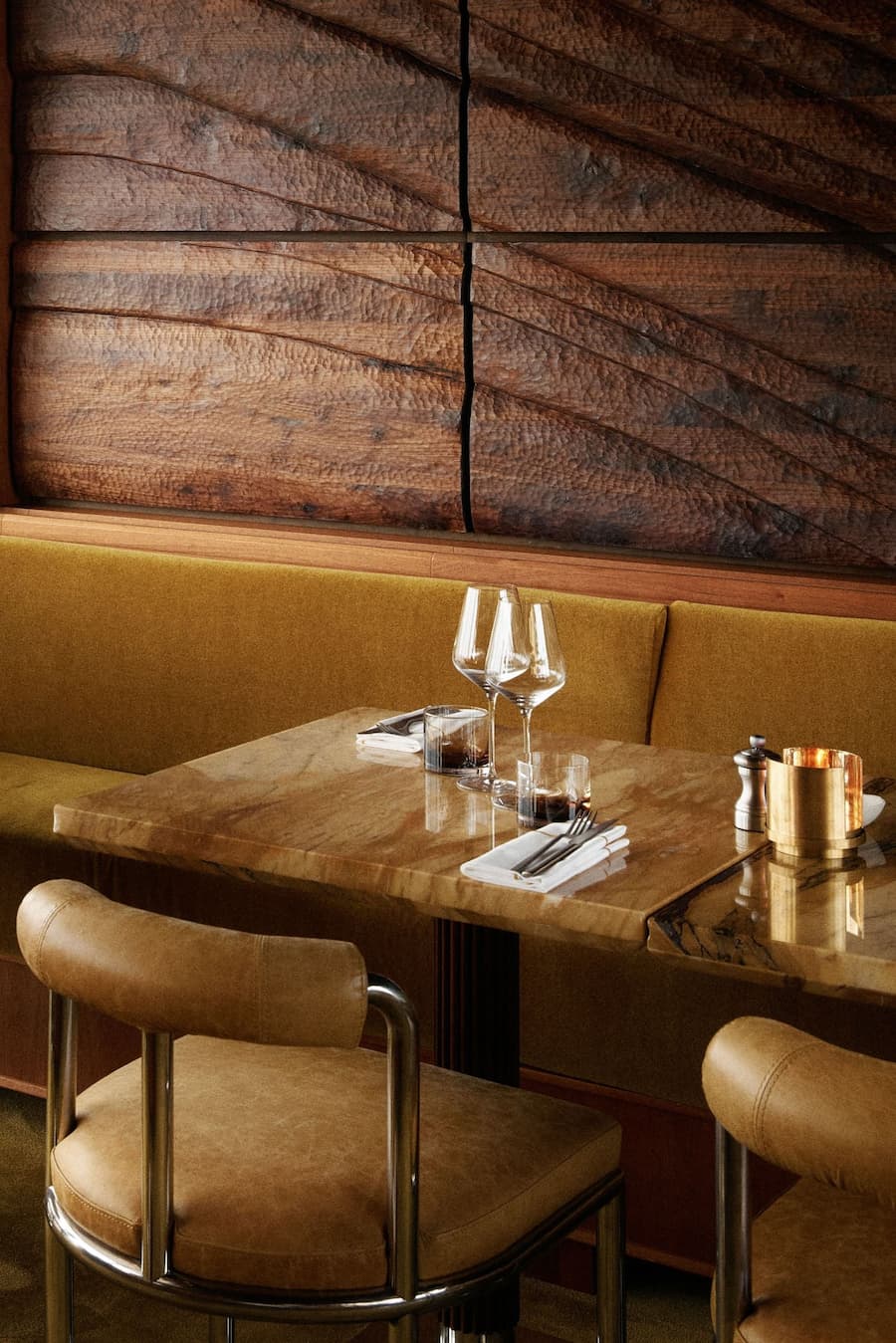 Close-up of marble dining table and upholstered chair in refined hospitality interior