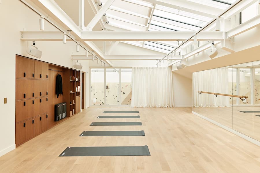 Minimal yoga studio with skylights, mirrored wall and soft natural lighting