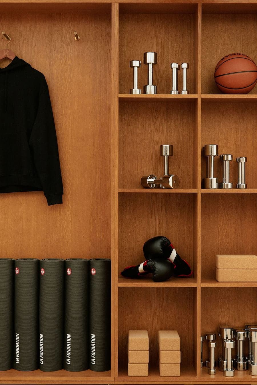 Custom wood shelving with fitness equipment, yoga mats and wellness accessories