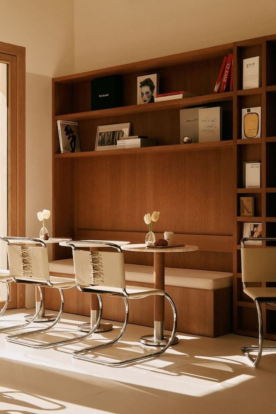 Warm-toned café lounge detail with integrated bench seating and curated shelving