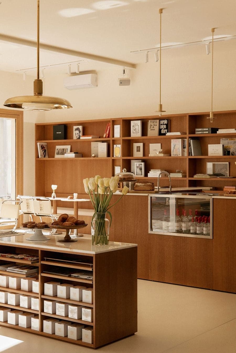 Minimalist café counter with pastries, floral arrangement and custom display shelving