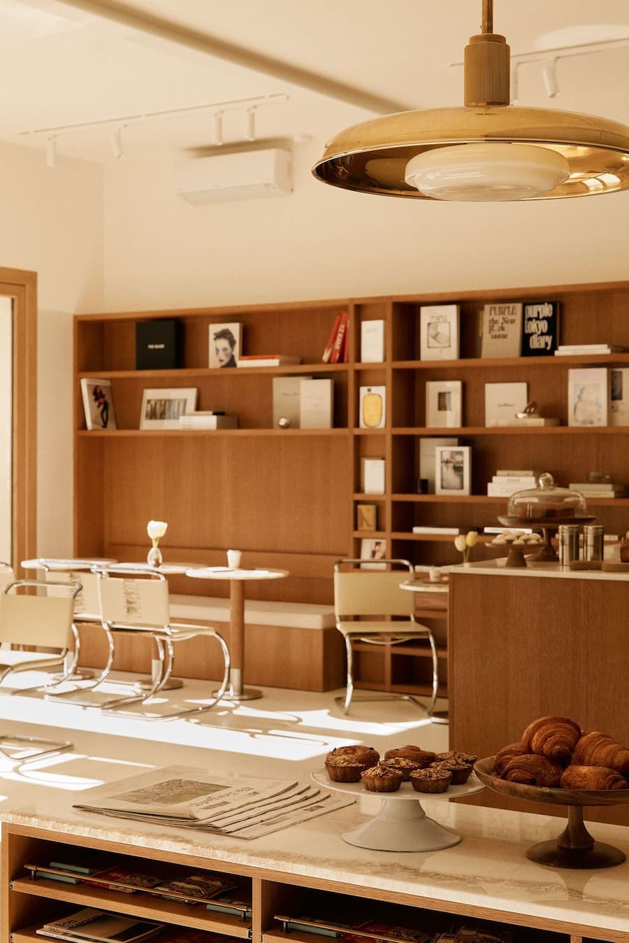 Designer lighting above a contemporary café interior with warm wood finishes