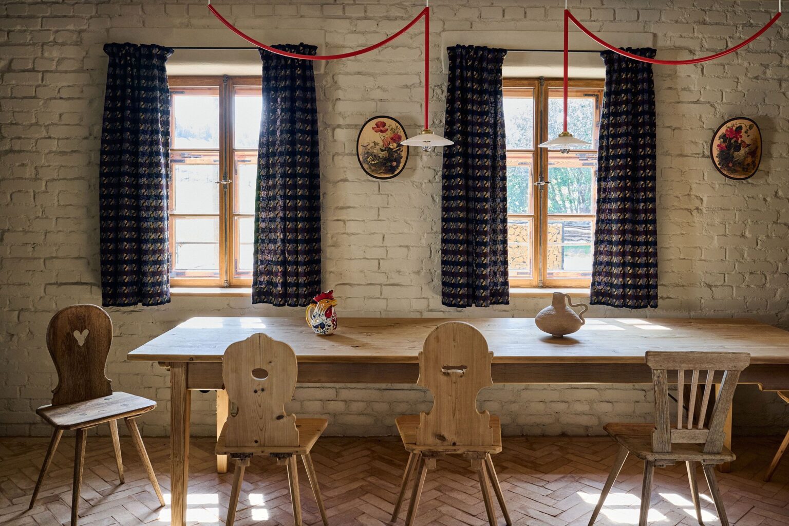 Traditional Bavarian farmhouse interior with wooden furniture, brick walls, and natural daylight from twin windows