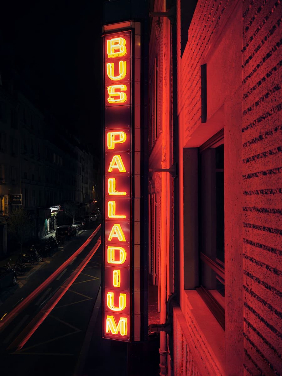Historic Bus Palladium neon sign on the Paris hotel facade at night by Studio KO