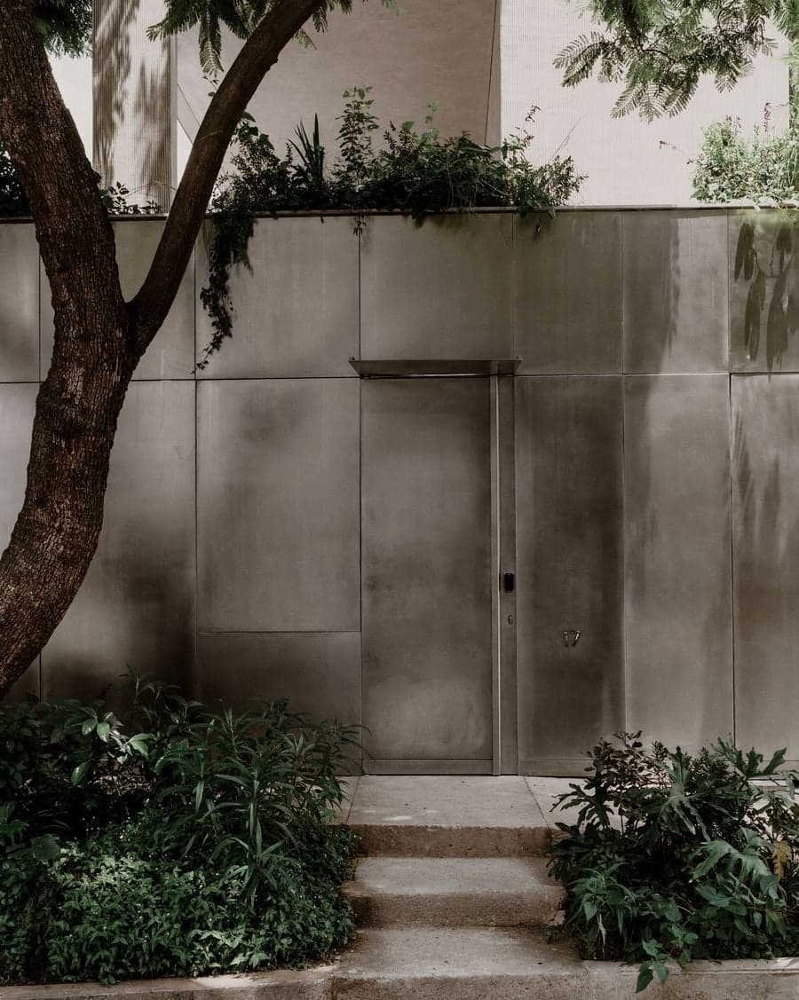 Hidden entrance integrated into the reflective street facade of Barrancas House