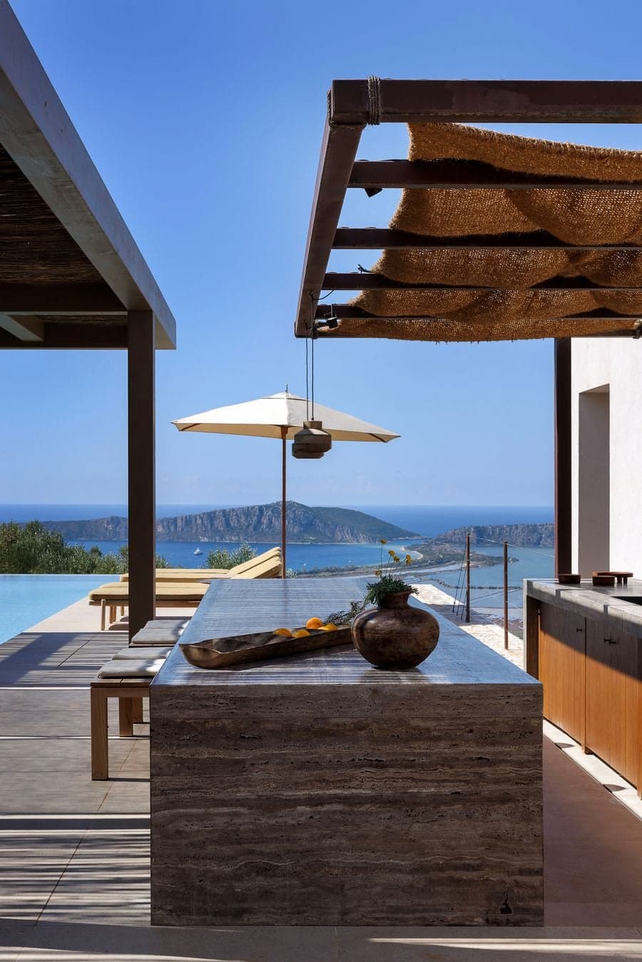 Travertine outdoor kitchen framed by panoramic views across Navarino Bay