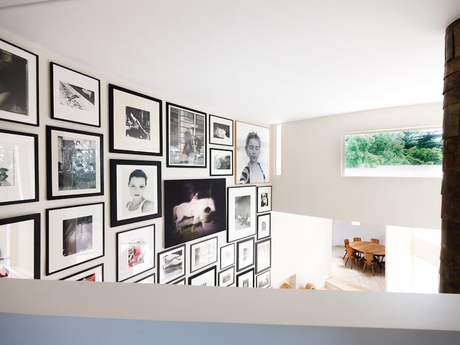 Photography gallery wall overlooking the dining space inside Villa Bank designed by Émile Sala for Casa Ideale