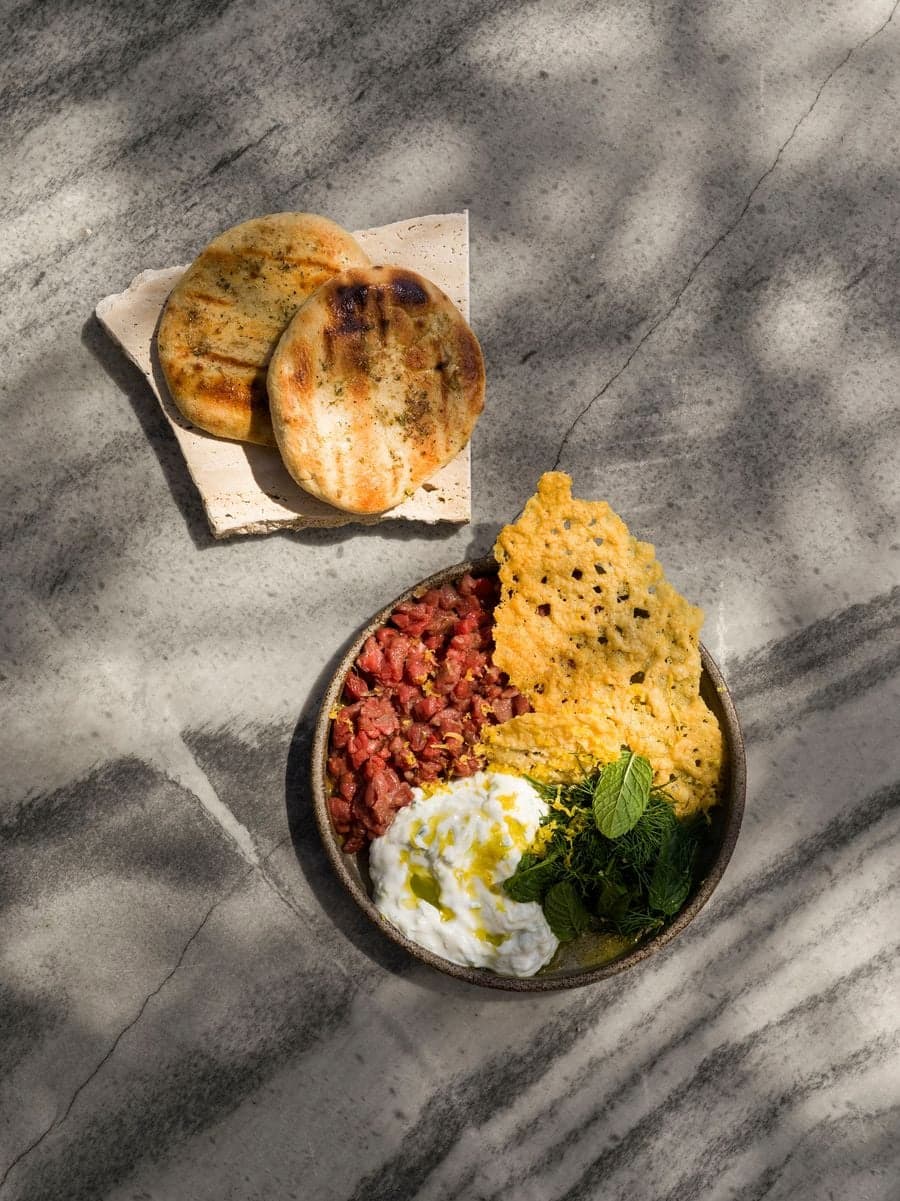 Seasonal Greek dish served on a natural marble tabletop at YAPA Antiparos featuring locally sourced Mediterranean ingredients