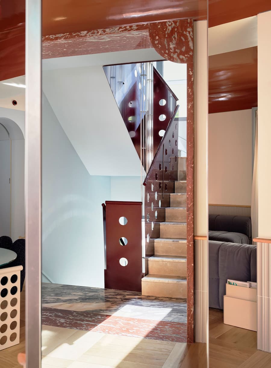 Perforated steel staircase connecting the levels of the renovated Madrid villa.