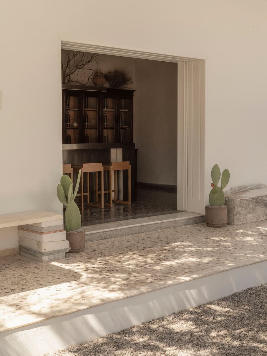 Seamless transition between the outdoor marble courtyard and indoor stainless steel bar at YAPA Antiparos restaurant