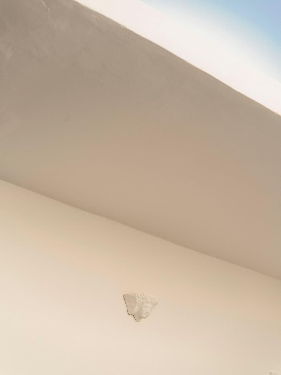 Traditional Cycladic wall light integrated into the white plaster architecture of YAPA Antiparos restaurant in Greece
