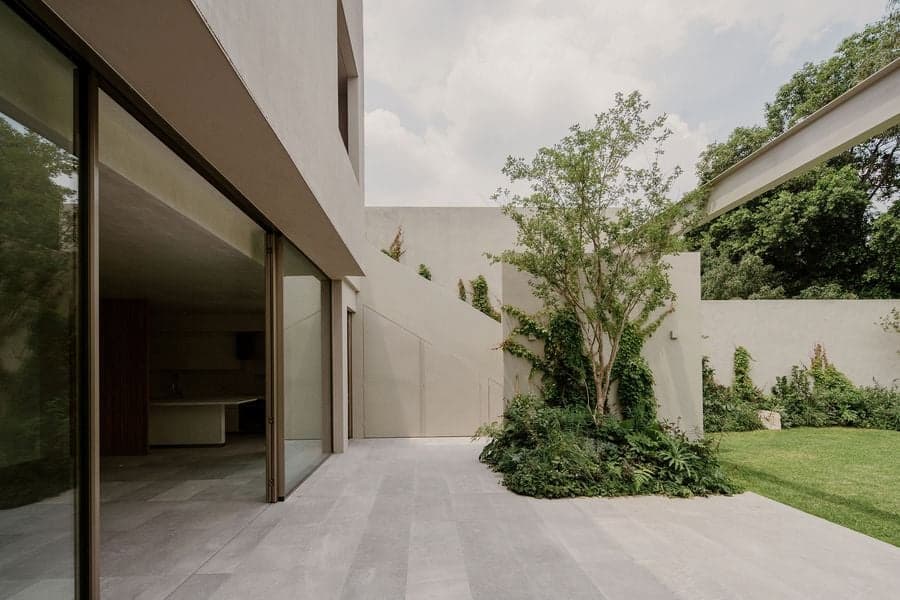 Sliding glass walls extending the living area into the landscaped courtyard