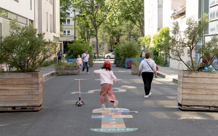 Children playing in a redesigned school street public space in Paris